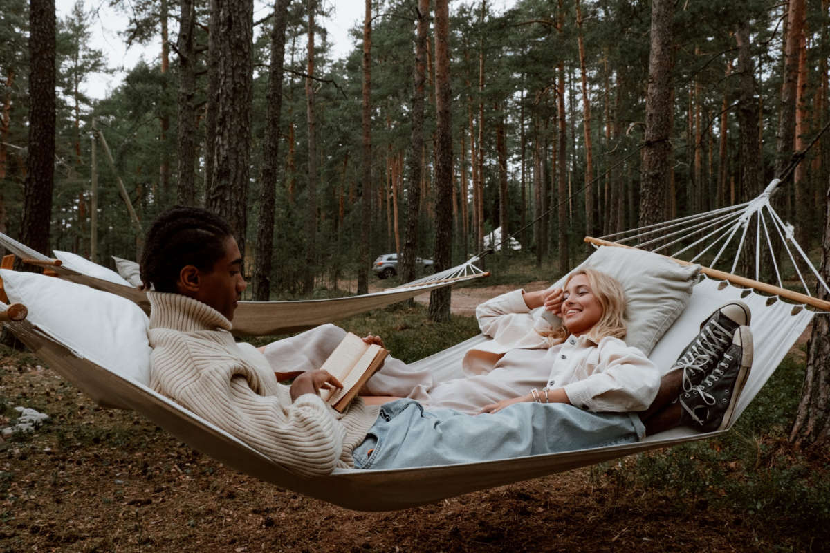 Two people relaxing together in a pine forest